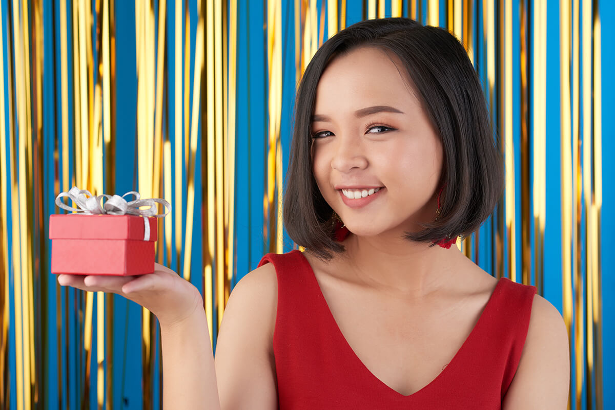 woman in red holding gift